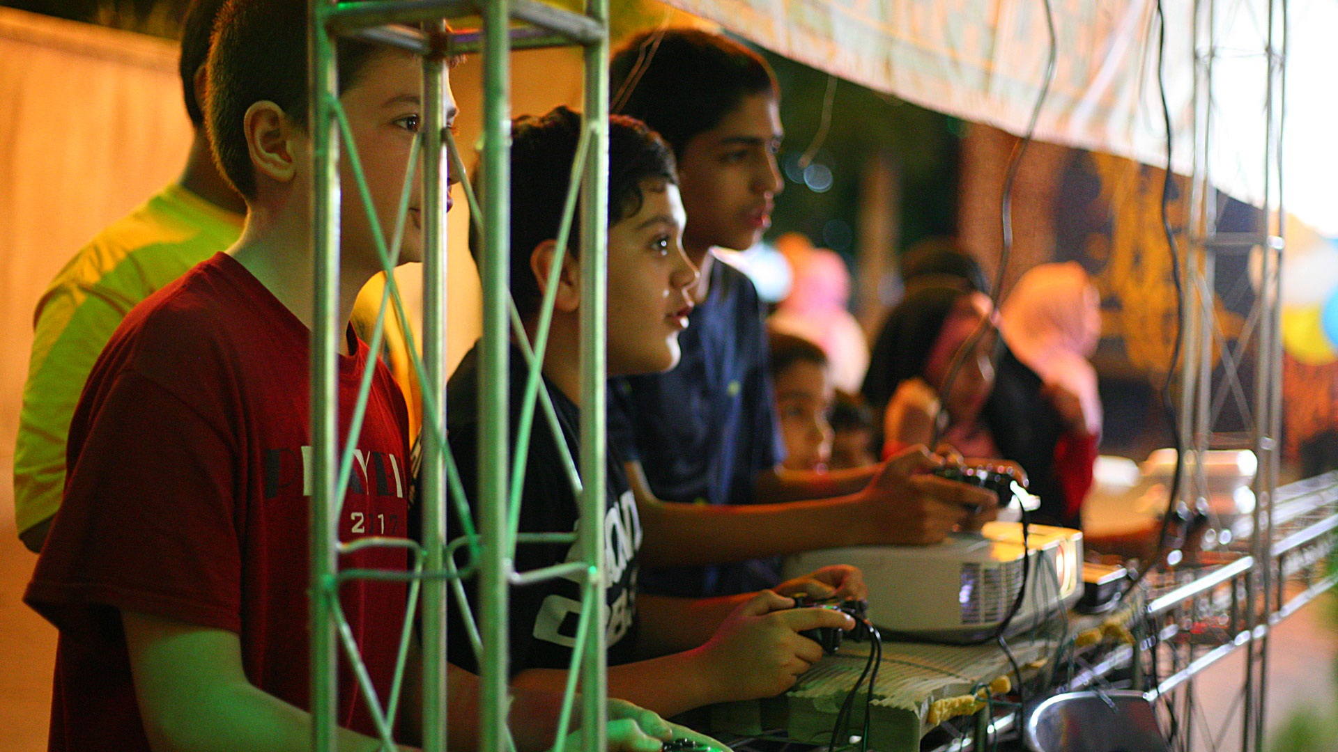 بچه‌های محله در حال تجربه‌ی یک بازی رایانه‌ای هشت نفره